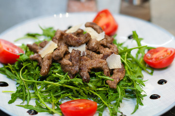 Tasty and juicy grilled meat with arugula, cheese, tomato sauce and spices