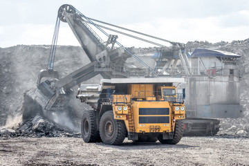 Ore loading with a powerful excavator. Loading a large mining truck.