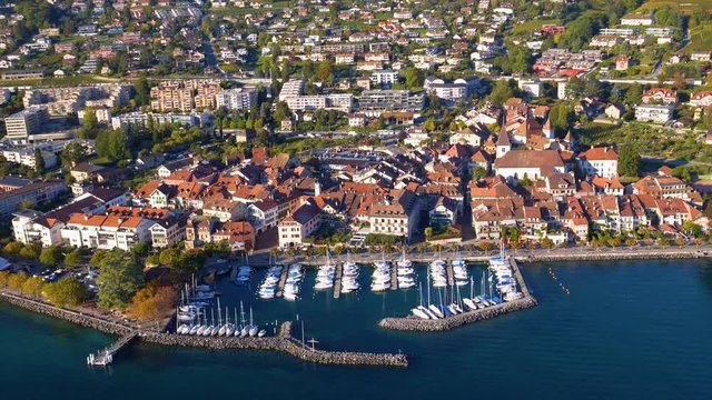 Aerial flyby over Lutry medieval town and harbour. Autumn sunset colors on Lavaux area, Switzerland