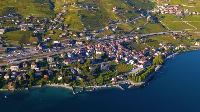 High altitude aerial flyby over Cully village on the shore of Lake Leman at sunset. Lavaux, Switzerland