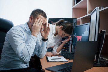 Lost a lot of money. Team of stockbrokers are having a conversation in a office with multiple display screens