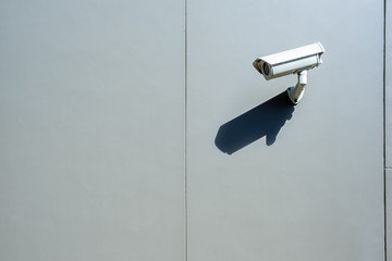 Surveillance wall mounted outdoor camera with harsh daylight shadow and copy space
