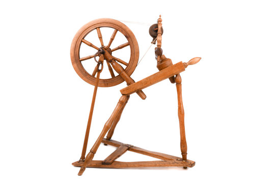 Old wooden yarn spinning wheel isolated on a white background. Very old wheel and spokes of a hand crafted spinning wheel made from natural wood. Historical working tool. Isolated on white background.
