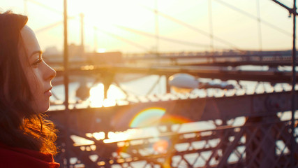 Obraz na płótnie Canvas Young girl on the bridge at sunset
