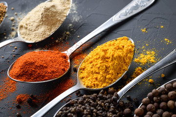 Various spices spoons on stone table.On dark concrete background.Herbs and spices on wooden table.  Top view with space for your text