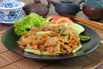 Noodles. Vegetarian food : Stir fried flat noodle with black soy sauce, tofu, carrots and green vegetables. Vegetarian food for vegetarian festival. Thai style stir fry flat noodle. (Pad See Ew)