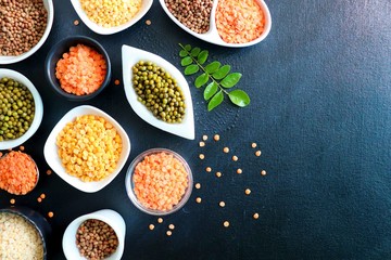 Composition of dry legumes. Assortment of colorful legumes in bowls. Lentils, Moth beans, Mung Beans, Masoor or red lentils, Split Chickpea, Toor Dal, Raw Split Mung Bean Lentils, Yellow Split.