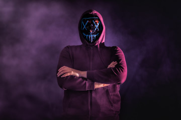 A man in a mask surrounded by smoke in a old building. Horror / Halloween Concept