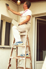 Construction worker plaster a wall.