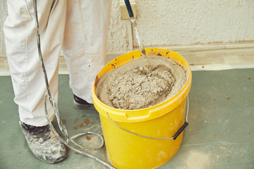 Worker using machine for plastering.