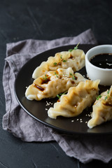 Wonton stuffed with soy sauce on a dark table