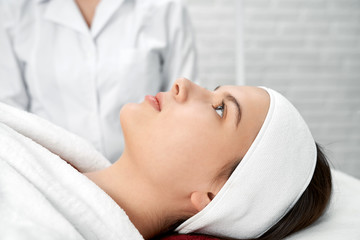 Fototapeta na wymiar Female client of cosmetology center lying on massage table.