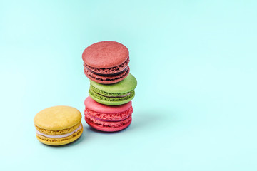 Assorted colorful macaroons on mint green background with copy space.