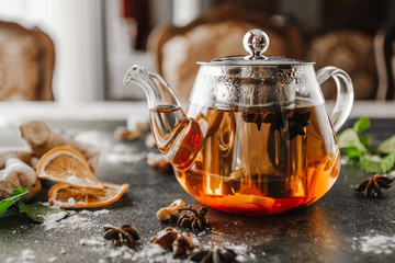 Leaf tea in a glass teapot on the black table