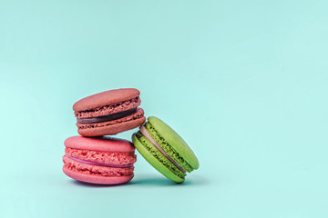 Assorted colorful macaroons on mint green background with copy space.