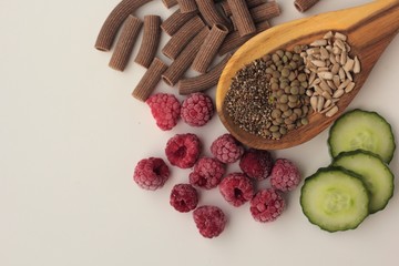 Sample foods from low-GI PCOS (Polycystic Ovary Syndrome) diet. Lentils, chia seeds, sunflower seeds, buckwheat pasta, raspberries and cucumber. 