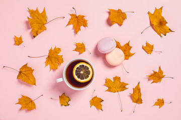 Cozy autumn composition. Tea cup with slices of lemon and maple leaves.