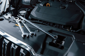 Top view. Repair tools lying down on the engine of automobile under the hood