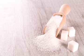 White cane sugar on a light wooden background