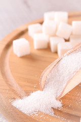 White cane sugar on a light wooden background