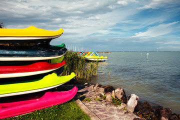 Colorful funny crocodile shaped children canoes and kayaks on the coast of the Lake Balaton on a...