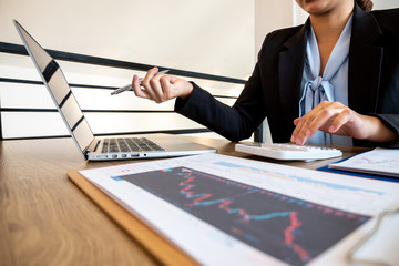 Business women are planning business investments related to shares By analyzing and calculating the...