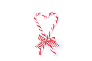 Sweet candy canes with bow isolated on white background