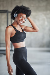 Fototapeta na wymiar Alone in the room. Portrait of african american girl in fitness clothes having a break after workout