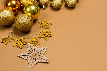 Adornos de Navidad bolas doradas sobre fondo marrón liso. Vista superior. Copy space