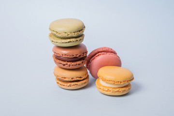 Macarons de diferentes colores y sabores sobre un fondo celeste pastel.