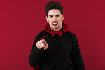 Image of angry vampire man in black halloween costume pointing finger