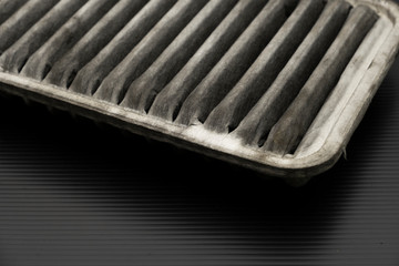 Old dirty automotive engine air filter isolated on black background