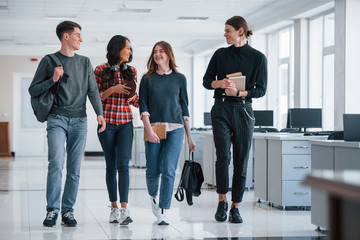 We have done nice piece of work today. Group of young people walking in the office at their break time