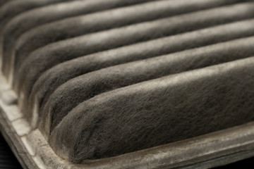 Old dirty automotive engine air filter isolated on black background