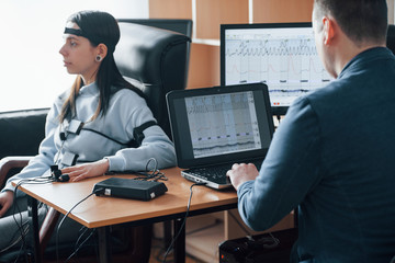 Testing wife for fidelity. Girl passes lie detector in the office. Asking questions. Polygraph test