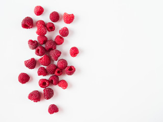 Heap of fresh ripe red raspberries on white background. Raspberry with copy space for text or design. Top view or flat lay. - obrazy, fototapety, plakaty