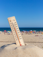 Thermometer for the temperature on the beach, in the summer in the heat. Global warming.
