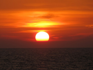 beautiful red sunset over the ocean. Bright sunset with large yellow sun under the sea surface. sundown seascape