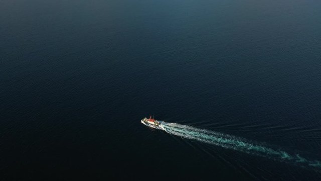 Follow aerial view of the large empty container ship sailing in sea to loading port