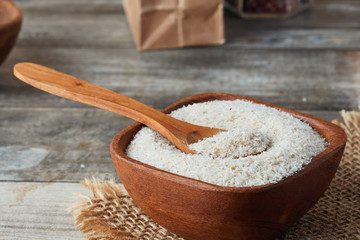 Psyllium (ispaghula) husk in wooden bowl on rustic background