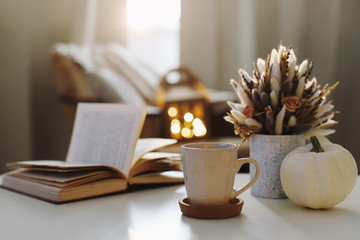 Autumn still life. Coffee cup, flowers, book and pumpkin. Hygge lifestyle, cozy autumn mood. Flat lay, Happy thanksgiving 