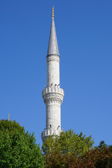 Fototapeta na wymiar Image of architectural fragment of one minaret on blue sky background in Istanbul city, Turkey.