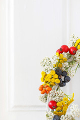 Woman shows how to make autumn wreath with rose hip, tansy and spiraea
