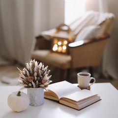 Autumn still life. Coffee cup, flowers, book and pumpkin. Hygge lifestyle, cozy autumn mood. Flat lay, Happy thanksgiving 