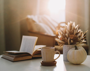 Autumn still life. Coffee cup, flowers, book and pumpkin. Hygge lifestyle, cozy autumn mood. Flat lay, Happy thanksgiving 