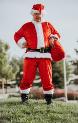 Obraz premium Stock photo of Vertical photo of papa noel without beard with arms resting on the body and yawning. Christmas time