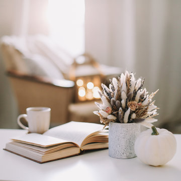 Autumn still life. Coffee cup, flowers, book and pumpkin. Hygge lifestyle, cozy autumn mood. Flat lay, Happy thanksgiving 