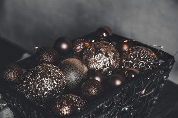 vintage christmas, new Year toys and decoration in basket on brown wooden table with garlands