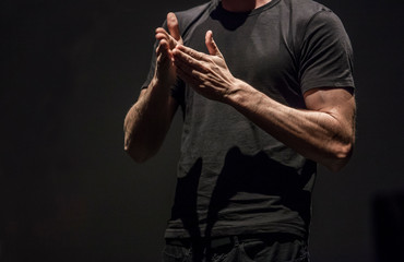 Sign language man interpreter gestures over stage during public event