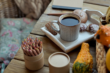 Autumn, pumpkins, hot steaming cup of coffee on a wooden table background. Seasonal, morning coffee, sunday relaxing and still life concept. Plans for the day.